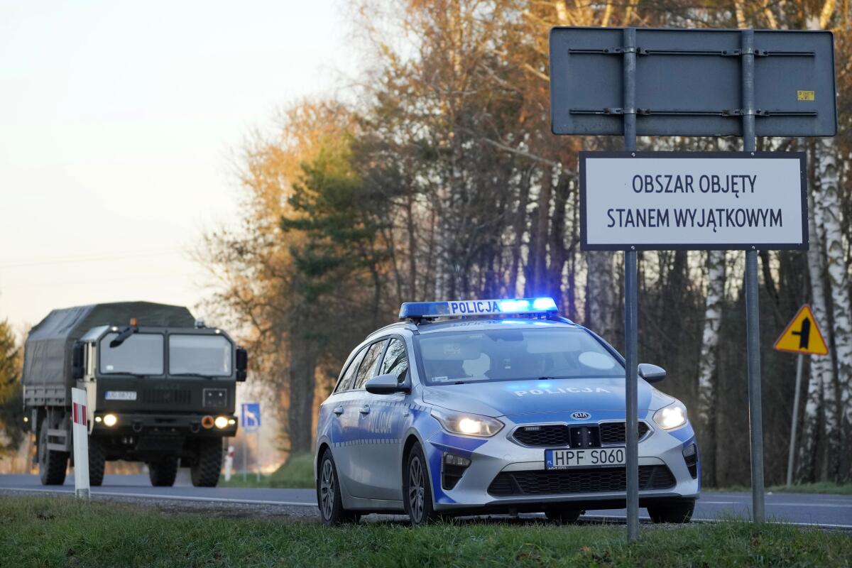 A Polish police car and a military truck near the border with Belarus