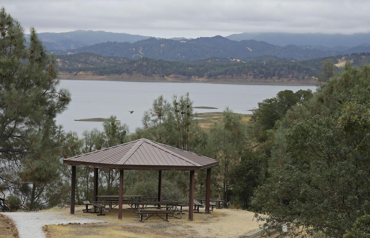 A covered picnic area amid trees with Lake Berryessa in the background