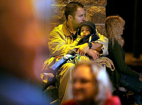 Northridge resident Shawn Wyatt holds his son, Harrison, 3, as they wait at 6 a.m. outside the Balboa Park Community Center in Encino, where the first of L.A. County's H1N1 vaccine clinics opened. Wyatt is a paramedic, which is among the groups given priority for the vaccine.