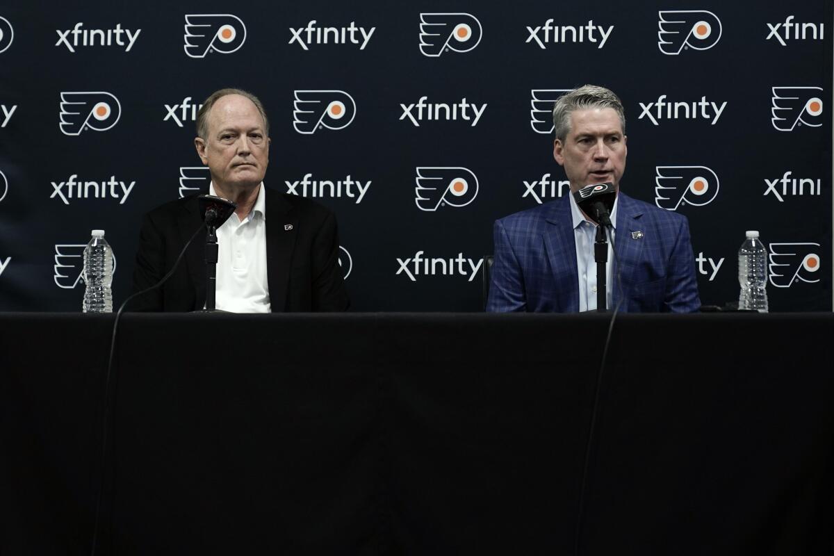 Philadelphia Flyers chairman Dave Scott, left, and Flyers general manager Chuck Fletcher take part in a news conference at the team's NHL hockey practice facility, Wednesday, Jan. 26, 2022, in Voorhees, N.J. The Flyers have lost a team-record 13 straight games. (AP Photo/Matt Rourke)