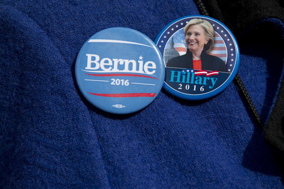A demonstrator wears campaign buttons for Bernie Sanders and Hillary Clinton during a rally in New York on March 31.