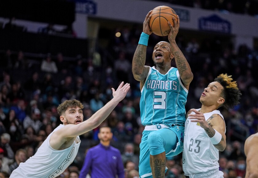 Charlotte Hornets guard Terry Rozier (3) drives to the basket between Oklahoma City Thunder guards Ty Jerome, left, and Tre Mann (23) during the first half of an NBA basketball game Friday, Jan. 21, 2022, in Charlotte, N.C. (AP Photo/Rusty Jones)