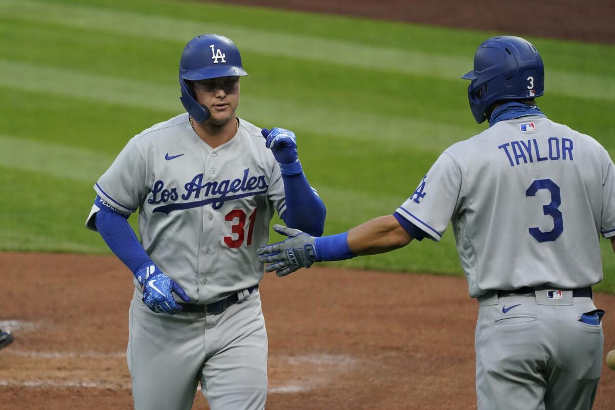 Dodgers' Joc Pederson is congratulated by Chris Taylor after hitting a home run against the Seattle Mariners on Aug. 19.