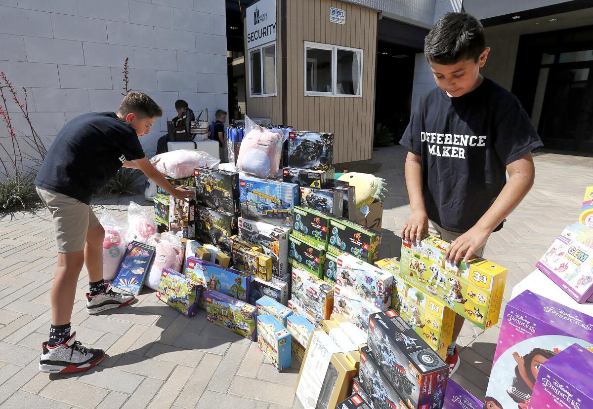 Anees Mudawar and Tim Mustard, from left, organize $3,000 worth of toys they purchased to donate to  Once Upon a Room.