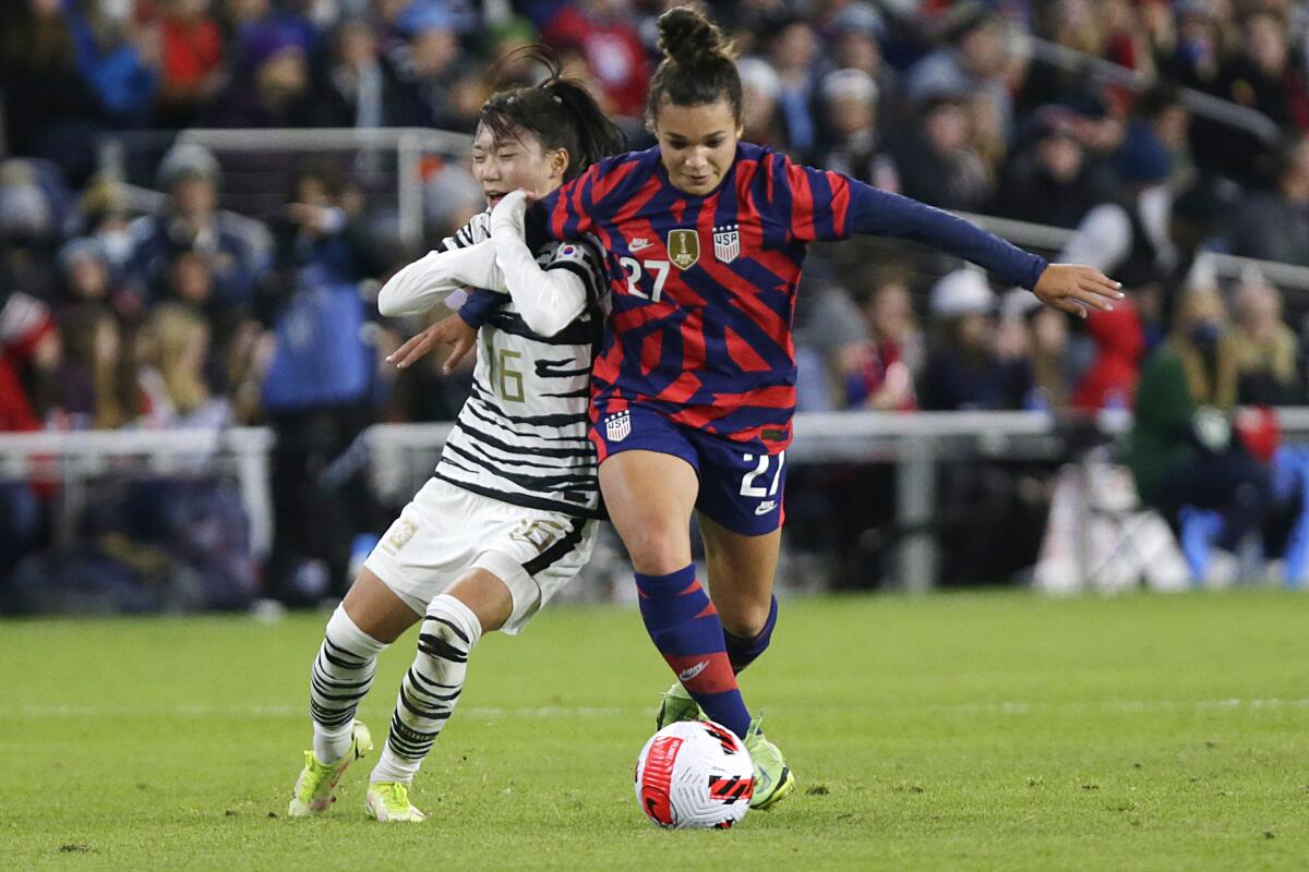 United States forward Sophia Smith controls the ball as South Korea midfielder Selgi Jang holds her.