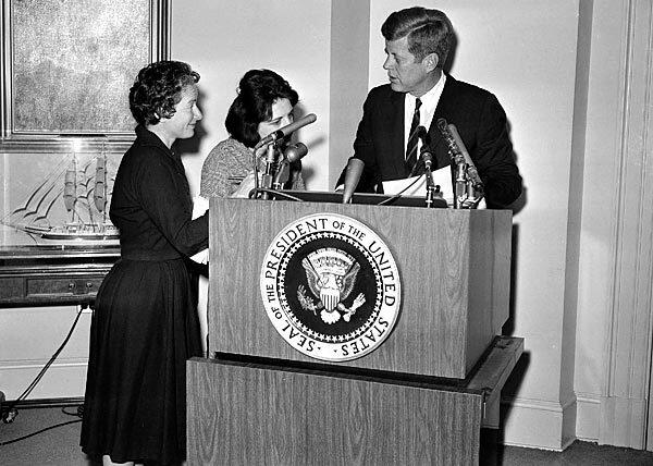 Correspondents Helen Thomas, center, of UPI and Frances Lewine of the Associated Press ask President Kennedy for copies of his announcement pledging federal help to quell rioting in Birmingham, Ala., in 1963. Thomas went to the White House at a time when female reporters were largely expected to write about the first lady's social calendar, fashion and manners.