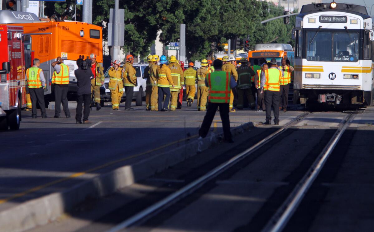 Fire officials gather at the site of a collision between a Metro Blue Line train and a bus in downtown Los Angeles in August 2012, which injured 31 people. Blue Line trains ran red lights 52 times from 2011 to 2014.