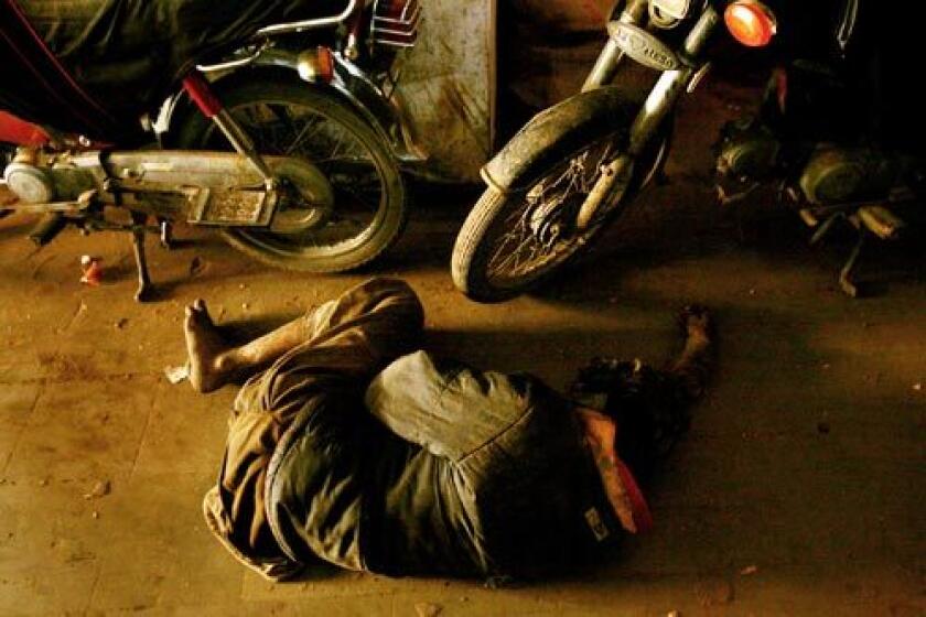 A man sleeps on the floor inside a central Karachi market in Pakistan. With a large chunk of the city's estimated 14 million people living in poverty, anti-government sentiment has been steadily growing. Although businesses reopened after a three-day mourning period for Benazir Bhutto, trade was light.