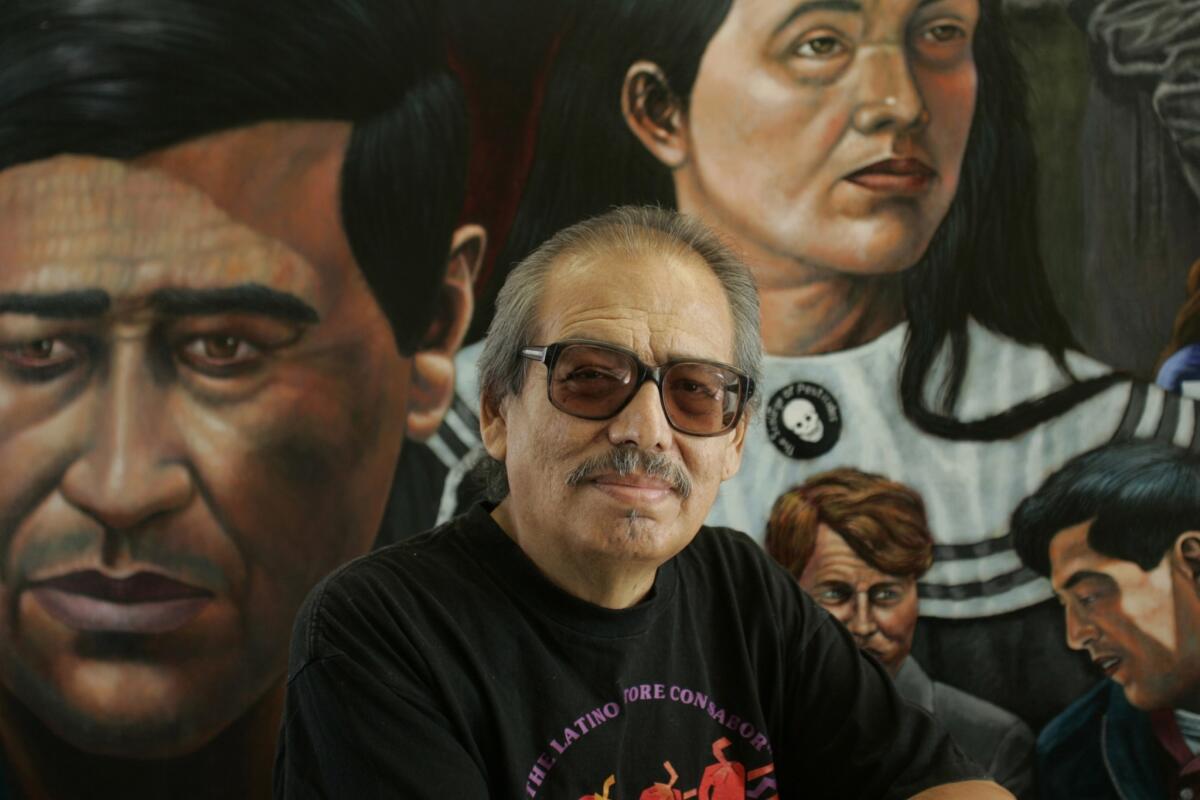 Emigdio Vasquez, shown in front of his mural "The Legacy of Cesar Chavez," was a muralist and painter who focused on Chicano issues. He is regarded as one of Orange County's pioneer muralists. He died Saturday at age 75.