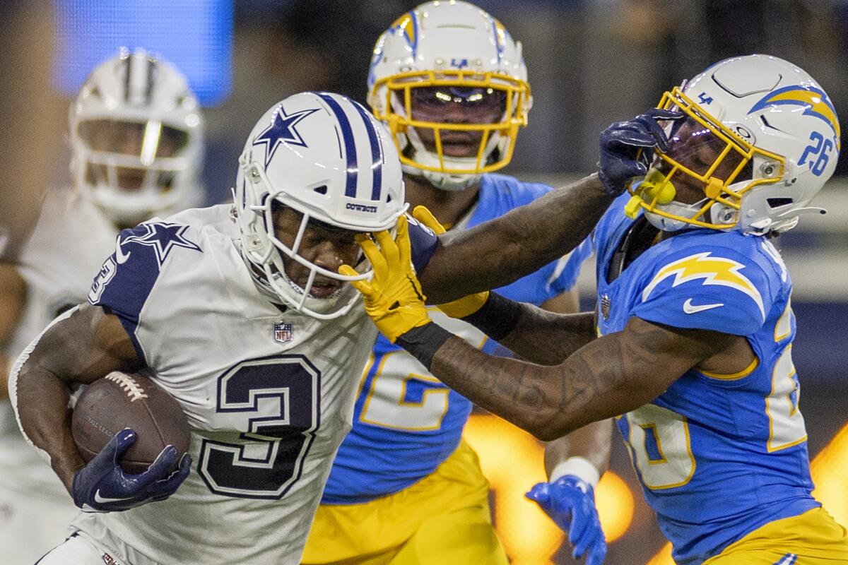 Chargers cornerback Asante Samuel Jr. is stiff-armed by a Cowboys player.