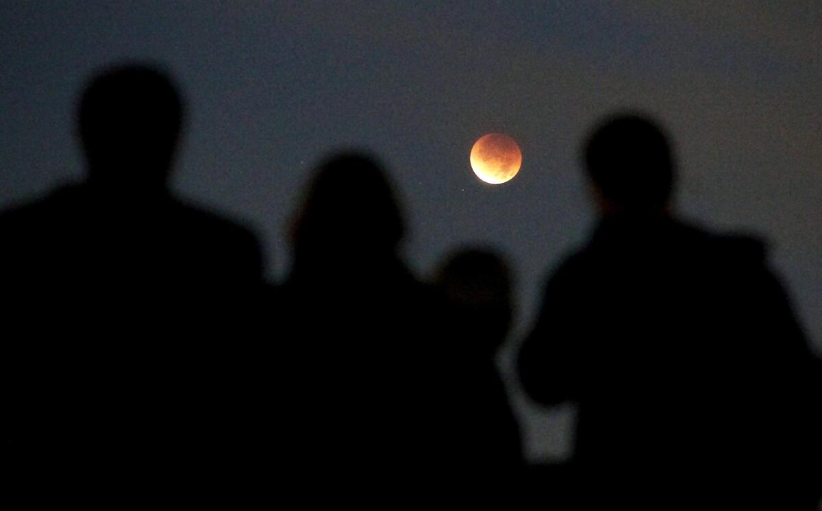 In this file photo of 2011, people gathered to view a full eclipse of the moon at Griffith Park Observatory in Los Angeles.