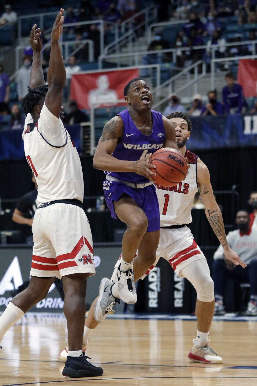 Abilene Christian guard Damien Daniels goes to the basket between Nicholls State guard Ty Gordon, left, and forward Jaylen Fornes (1) during the first half of an NCAA college basketball game for the Southland Conference men's tournament championship Saturday, March 13, 2021, in Katy, Texas. (AP Photo/Michael Wyke)
