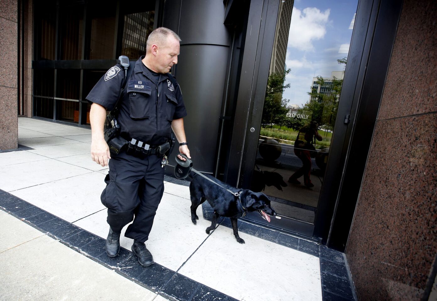Homeland Security Agent, Ron Miller, of San Antonio, works with his bomb sniffing dog, Mattie, along the Earle Cabel Federal Building in downtown Dallas.