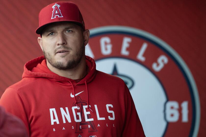 Anaheim, CA - July 18: Angels star Mike Trout walks in the dugout before a game.