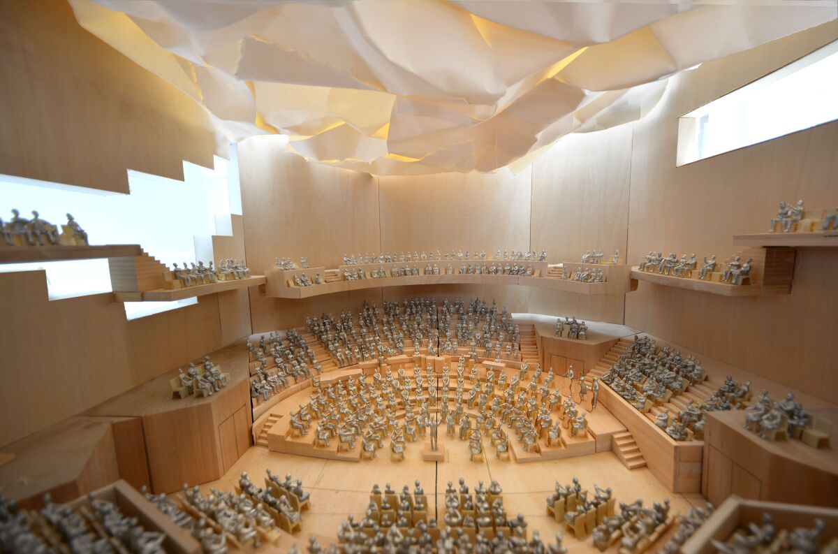 A model shows an interior schematic of concert hall seating under a billowing ceiling