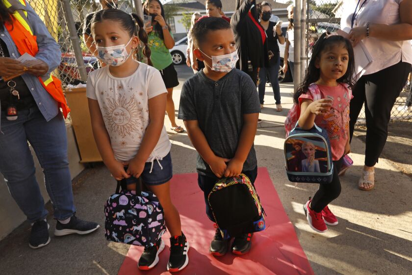 Los Angeles, Arleta, California-Aug. 15, 2022-Isabella Sosa, left, age 5, and her brother Daniel Sosa, age 4, carry their backpacks on the first day of school at Vena Avenue Elementary School in Arleta, California on Aug. 15, 2022. Students from the Los Angeles Unified School District head to school at Vena Avenue Elementary & Gifted/High Ability Magnet on Aug. 15, 2022. (Carolyn Cole / Los Angeles Times)