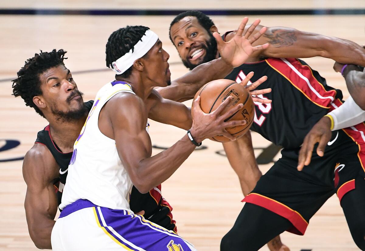 ORLANDO, FLORIDA OCTOBER 11, 2020-Lakers Rajon Rondo drives past Heat's Jimmy Butler.