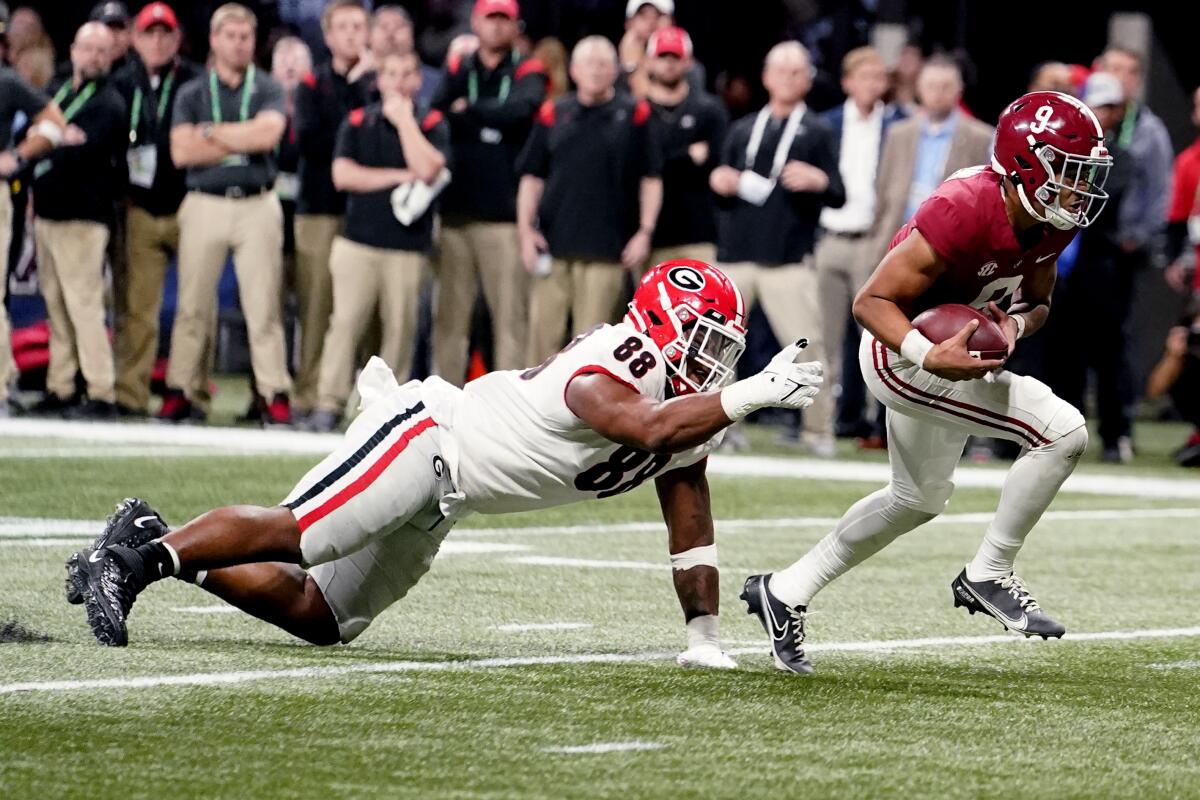 Alabama quarterback Bryce Young runs past Georgia defensive lineman Jalen Carter for a touchdown Dec. 4 in Atlanta.