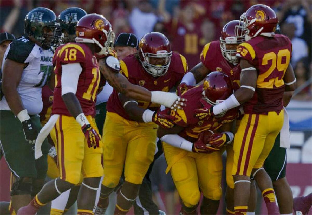 USC Trojans defensive tackle Christian Heyward (97) is swarmed by teammates after recovering a fumble against Hawaii.
