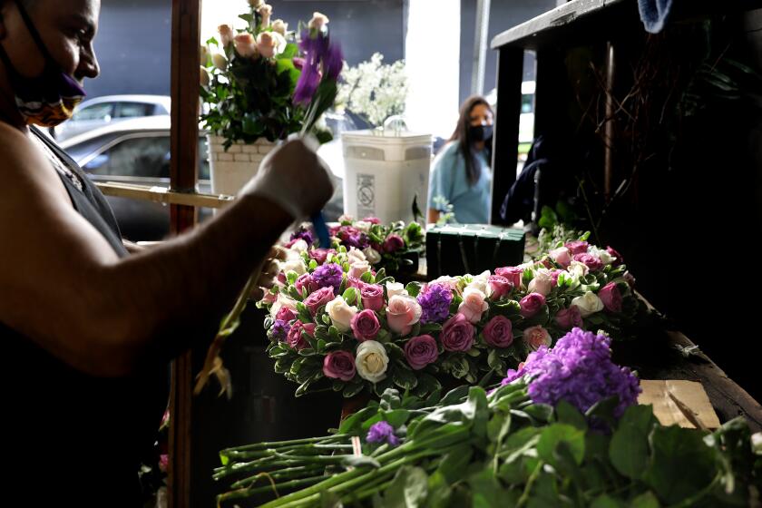 LOS ANGELES-CA-MAY 6, 2020: Jaime Miranda creates an arrangement at Lupita's Flowers in downtown Los Angeles on Wednesday, May 6, 2020. Flower wholesalers are allowed to reopen during the coronavirus pandemic in downtown Los Angeles ahead of Mother's Day weekend. (Christina House / Los Angeles Times)