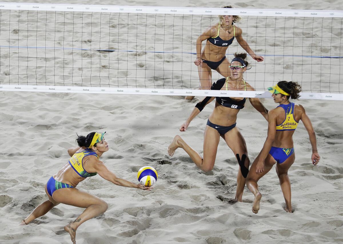 Brazil's Agatha Bednarczuk, left, reaches for a ball hit by Germany's Kira Walkenhorst, center right, as their teammates Barbara Seixas de Freitas, right, and Laura Ludwig, rear, look on during the women's beach volleyball gold medal match at the 2016 Summer Olympics in Rio de Janeiro, Brazil, Thursday, Aug. 18, 2016. (AP Photo/David Goldman)