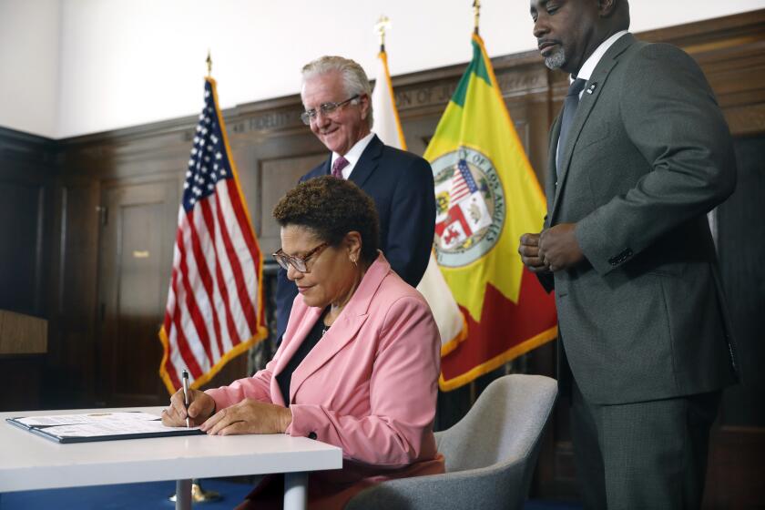 LOS ANGELES-CA-JULY 6, 2023: Mayor Karen Bass is joined by City Council President Paul Krekorian, at left, and Council President Pro Tem Marqueece Harris-Dawson, right, in signing an ordinance intended to accelerate the building of affordable housing by eliminating the site plan review process for those projects at LA City Hall on July 6, 2023. (Christina House / Los Angeles Times)