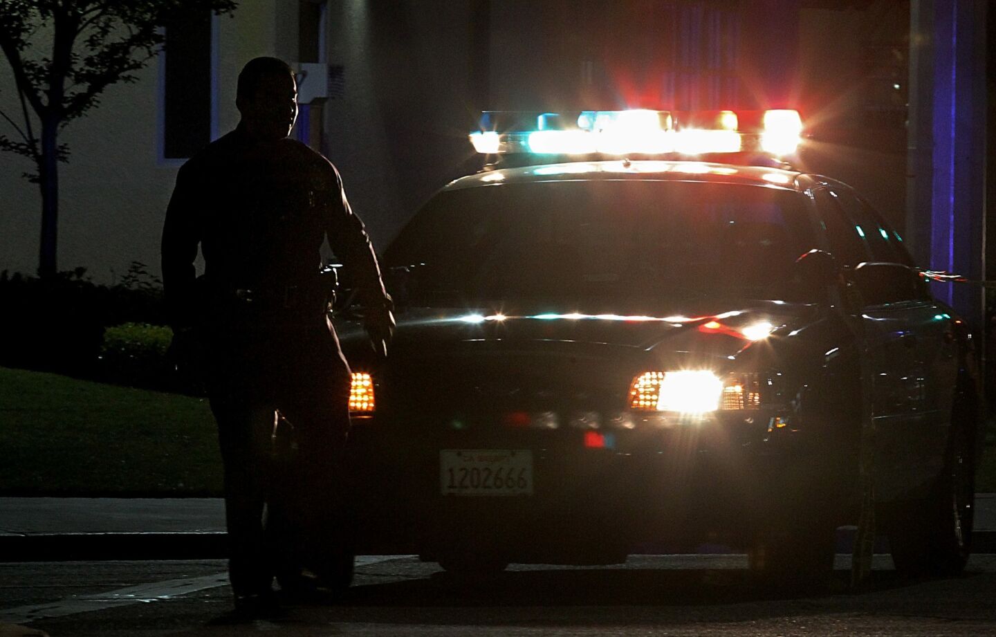 An LAPD officer stands guard at La Brea Avenue and Venice Boulevard, about a block from the station where the shooting occurred.
