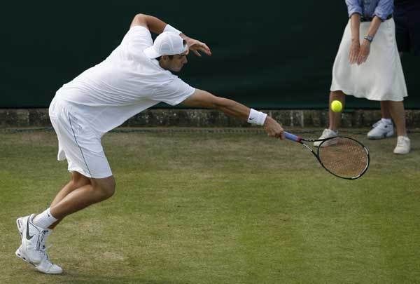 John Isner returns a ball to Nicolas Mahut during the Wimbledon Tennis Championships on June 23, 2010.