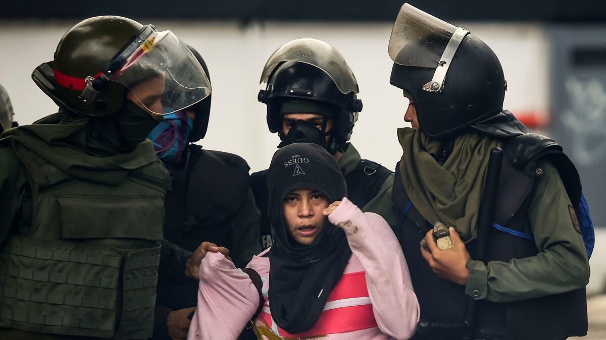 An anti-government activist is arrested during clashes Friday in Caracas. Despite a ban on protests leading up to an election Sunday, demonstrators took to the streets in some Venezuelan cities.