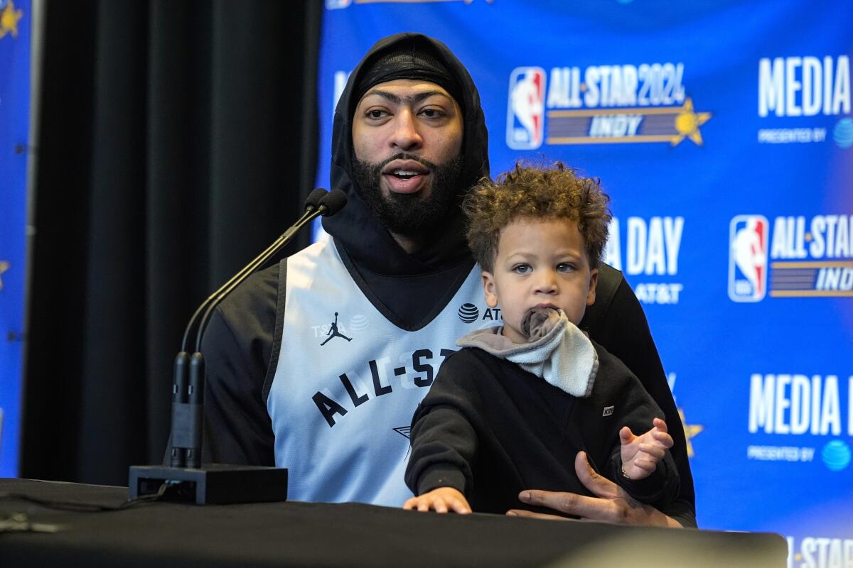 Lakers forward Anthony Davis holds son Jayce as he answers a question during All-Star Game media day.