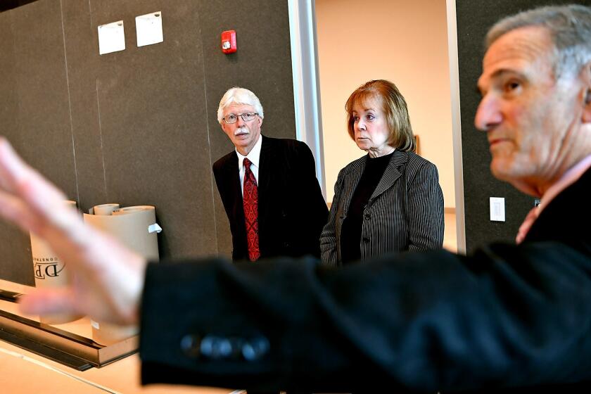 BioMed CEO David Meyer, right, gives a tour to Melanie and Richard Lundquist inside a new biomedical building in Torrance where they will announce a doantion of $70 million to the Los Angeles Biomedical Research Institute.