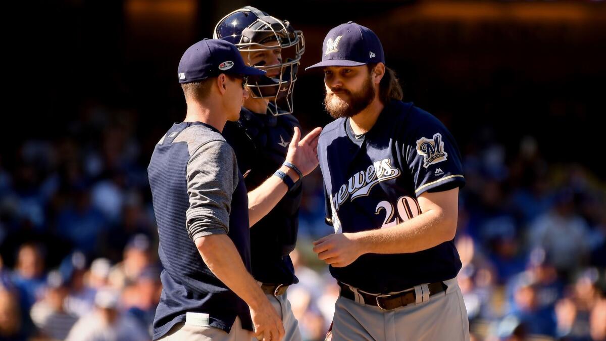 Starting pitcher Wade Miley is pulled from the game by Brewers manager Craig Counsell — after walking leadoff batter Cody Bellinger.
