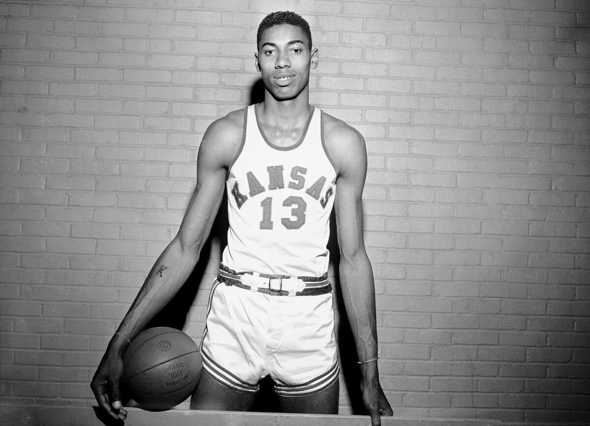 FILE - Wilt Chamberlain, Kansas' 7-foot basketball star, poses for a photo during a pause in practice in Allen Field House in Lawrence, Kan., March 1, 1957. In the 1957 NCAA college championship, North Carolina defeated Chamberlain and Kansas in triple overtime. (AP Photo/William P. Straeter, File)