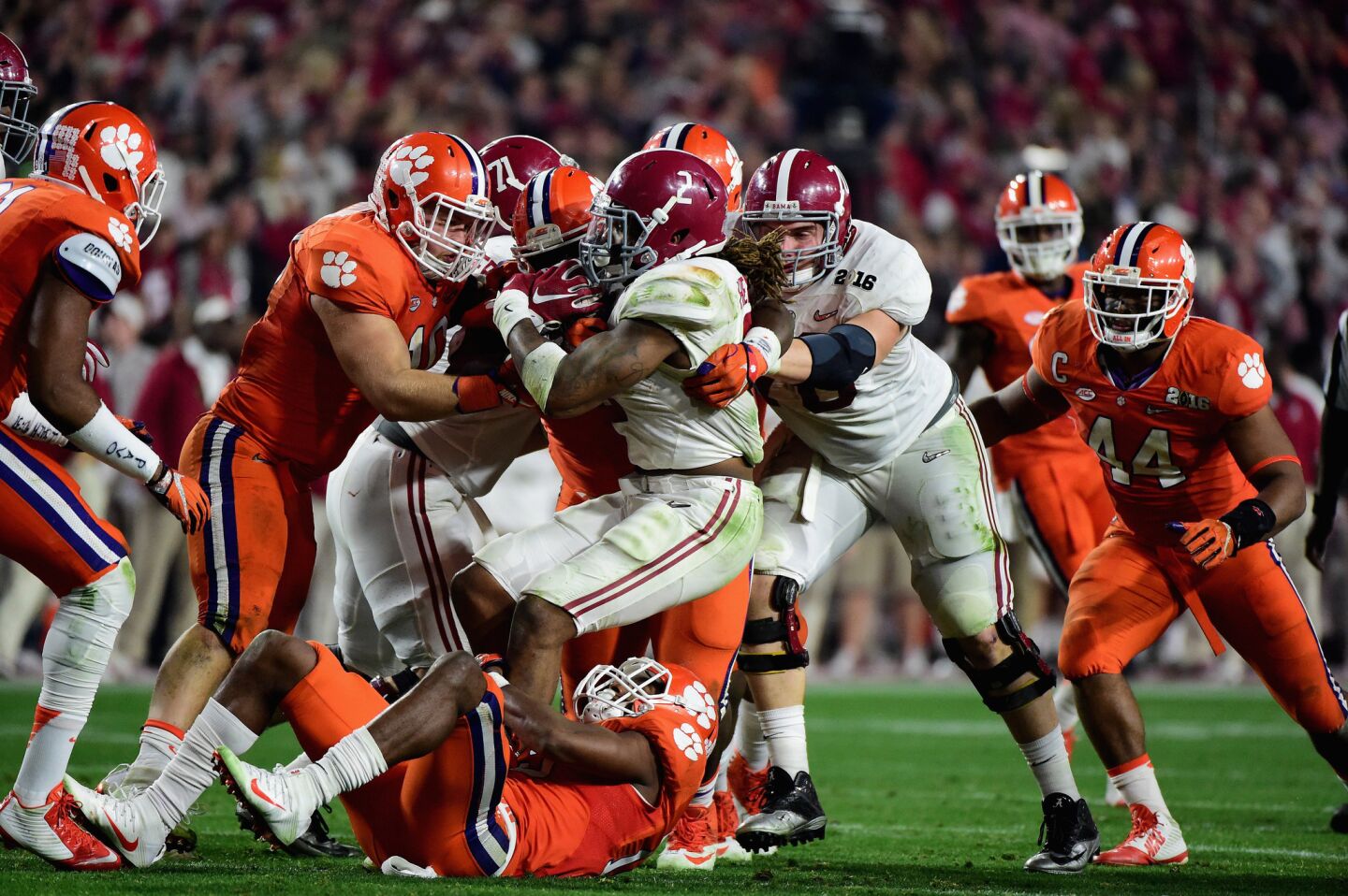 Alabama running back Derrick Henry (2) gets tackled in the second half by a gang of Clemson defenders.