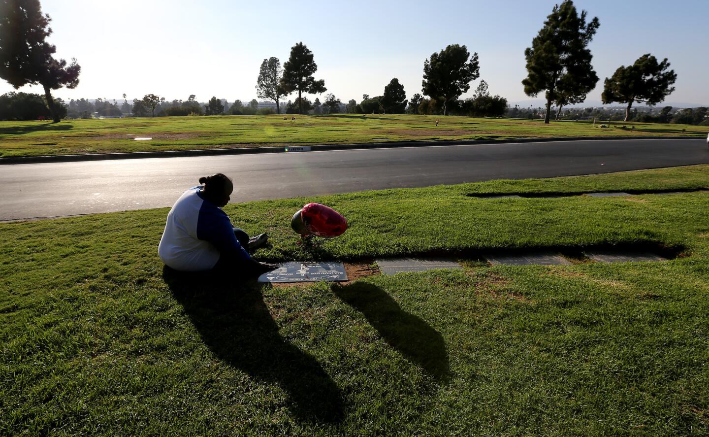 Barbara Pritchett-Hughes sits beside the grave of her son DeAndre Hughes during a visit to Inglewood Park Cemetery in October. Hughes was killed four months earlier at the age of 30. Another son, Dovon Terrell Harris, died in 2007.
