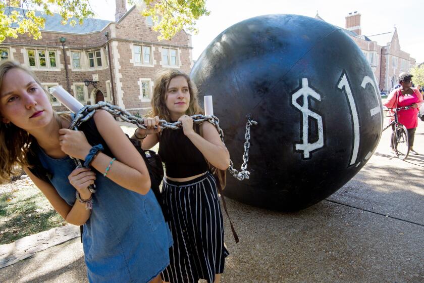 Students pull a mock "ball & chain" representing the $1.4 trilling outstanding student debt at Washington University in St. Louis, Missouri, where second presidential debate will be held between Republican nominee Donald Trump and his Democratic counterpart Hillary Clinton / AFP / PAUL J. RICHARDS (Photo credit should read PAUL J. RICHARDS/AFP/Getty Images) ** OUTS - ELSENT, FPG, CM - OUTS * NM, PH, VA if sourced by CT, LA or MoD **