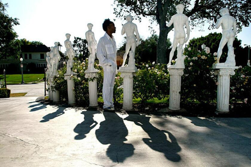 Miniature statues of Michelangelo's David curve along the front lawn of Norwood Young's home.