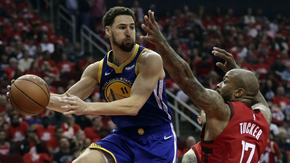 Golden State Warriors guard Klay Thompson looks to pass the ball as Houston Rockets forward P.J. Tucker defends during Game 6 of the NBA Western Conference semifinals on May 10.