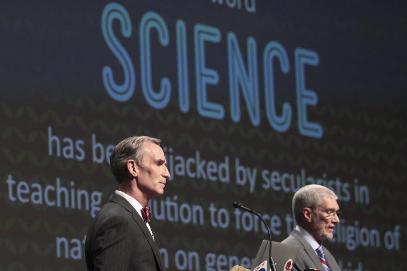 Bill Nye, left, looks on as Creation Museum head Ken Ham speaks during a debate on evolution Tuesday.
