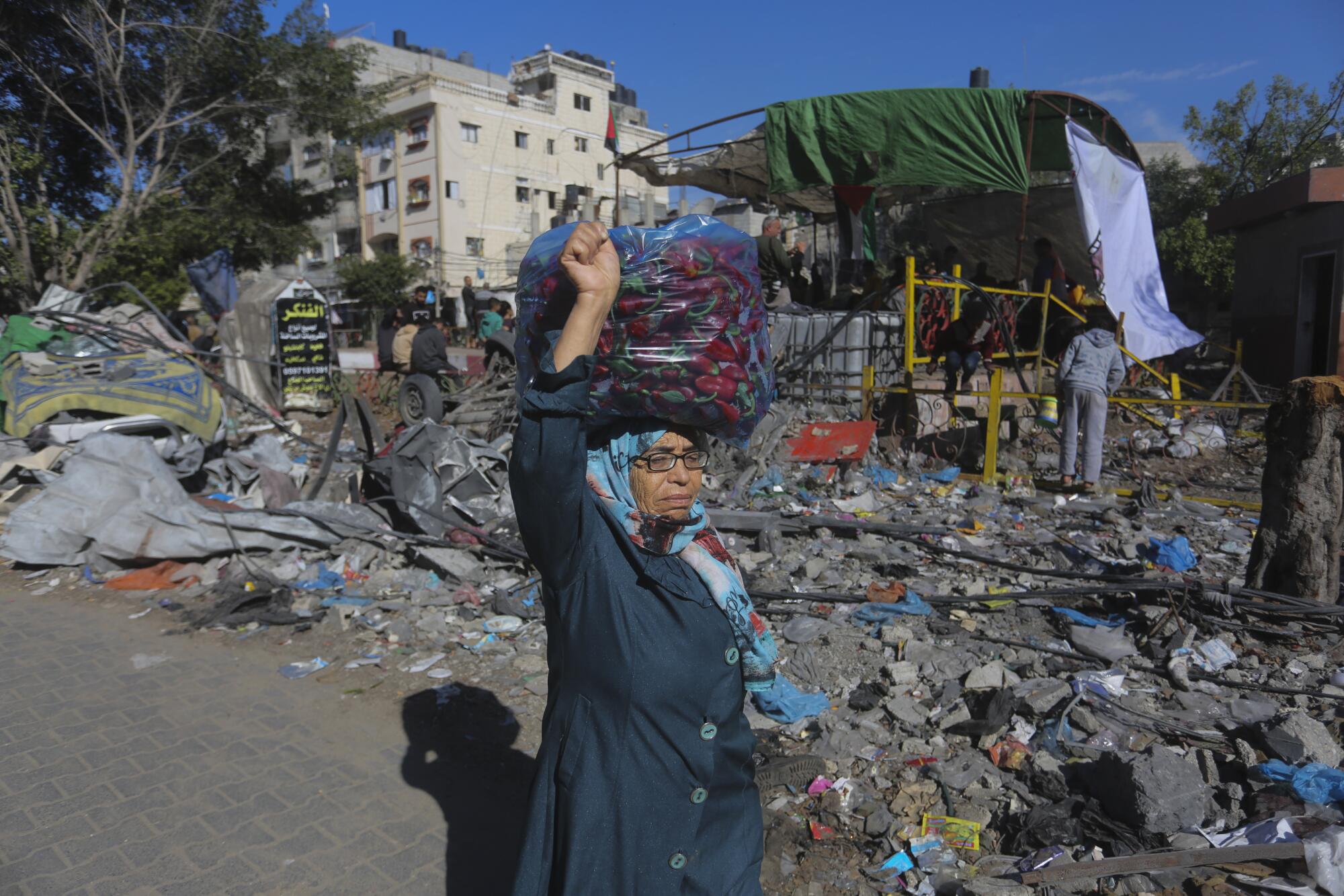 Person walking by destroyed buildings in Rafah, Gaza