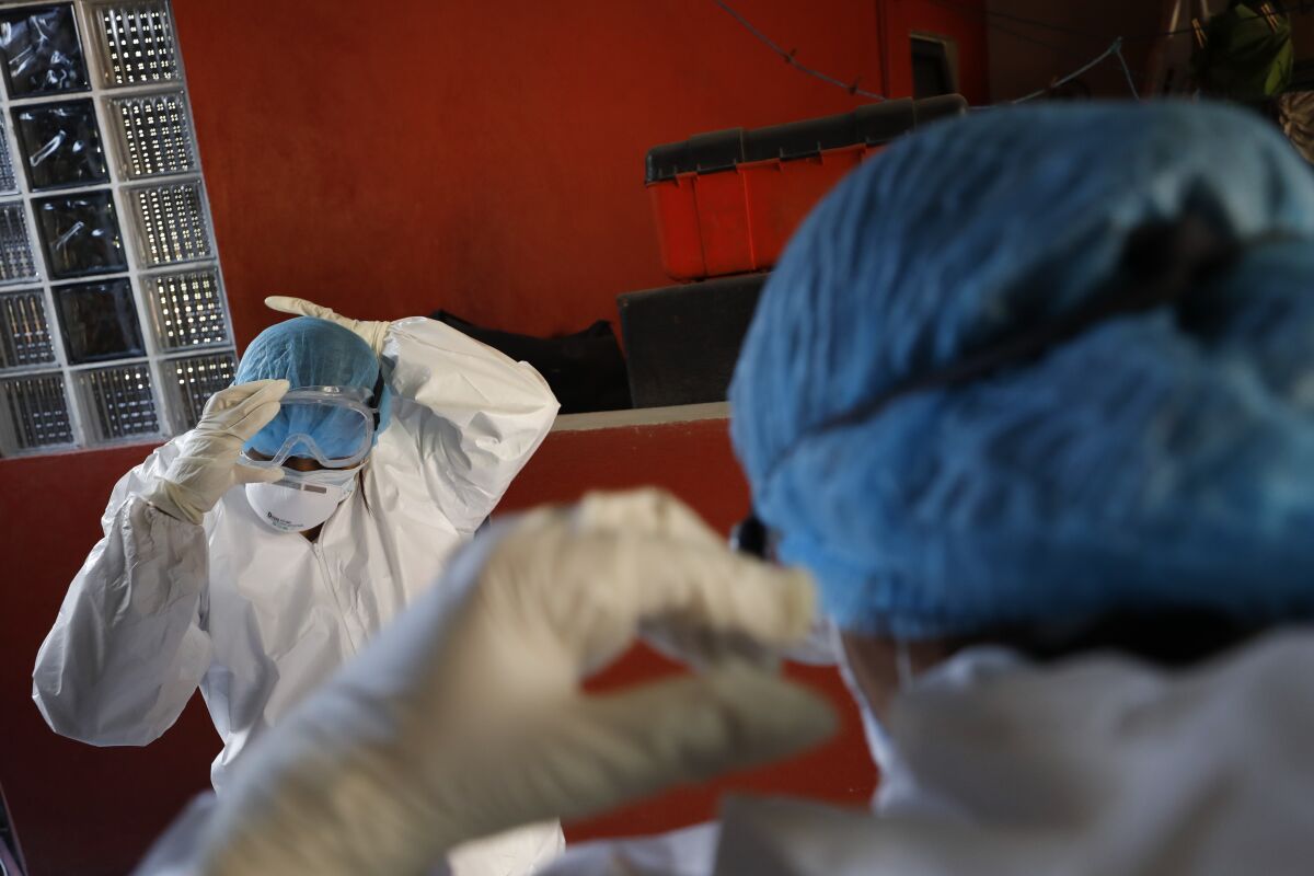 Doctors put on protective gear as they prepare to conduct a COVID-19 test in Mexico City on Thursday.