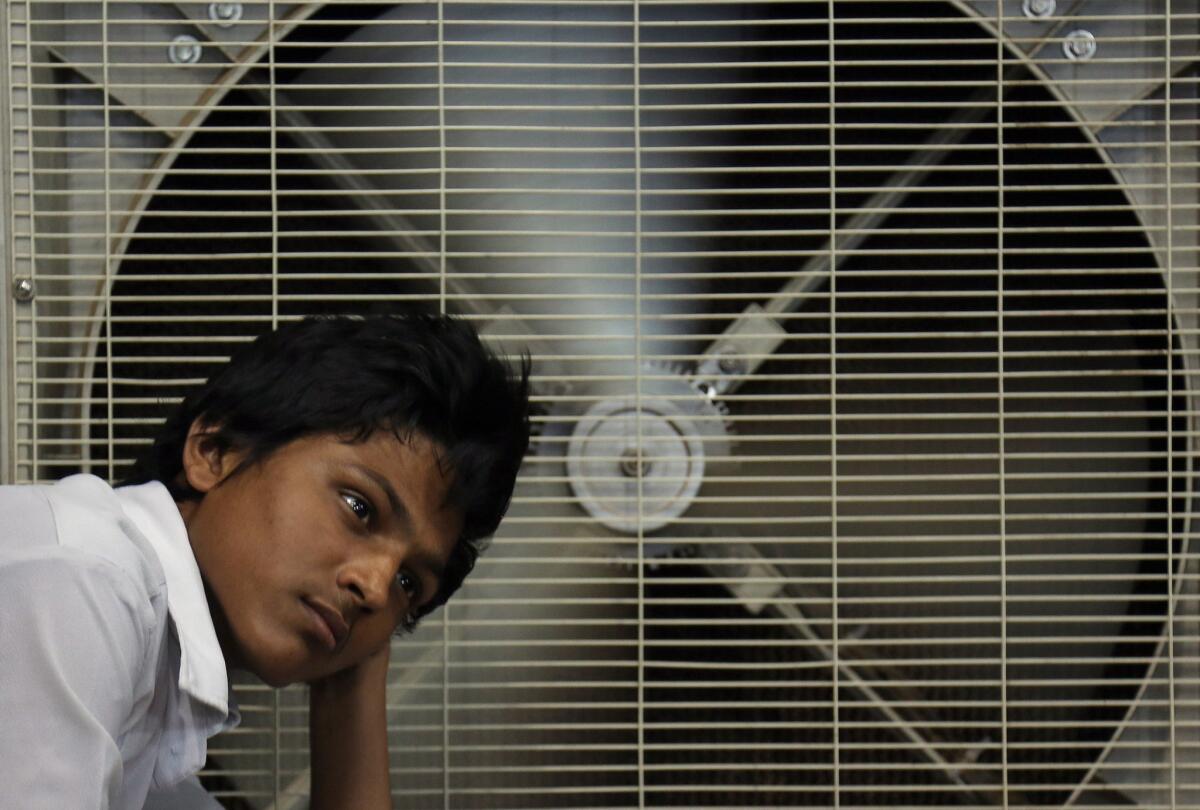 Un hombre descansa ante un ventilador para aliviar su calor en Hyderabad, India.