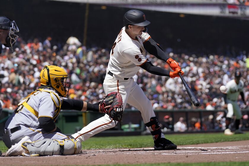 San Francisco Giants' Patrick Bailey, right, hits a two-run double in front of Pittsburgh Pirates catcher Austin Hedges during the second inning of a baseball game in San Francisco, Monday, May 29, 2023. (AP Photo/Jeff Chiu)
