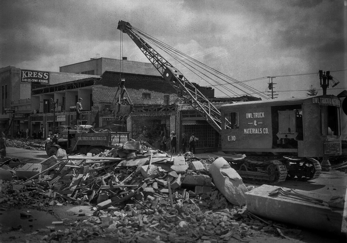 Cleanup of damage caused by the March 10, 1933, Long Beach earthquake. Location is unknown but this may be in Compton as one store sign is "Compton Hardware."