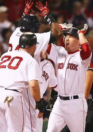 Kevin Youkilis (20) celebrates at home plate with teammate J.D. Drew and David Ortiz after Drew hit a grand slam home run in the first inning.