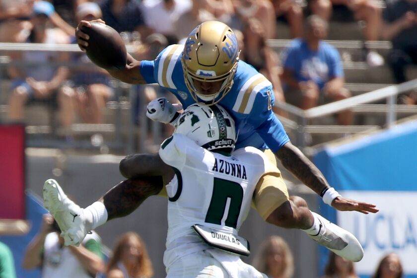 PASADENA, CALIF. - AUG. 28, 2021. UCLA quarterback Dorian Thompson-Robinson tries to hurdle.