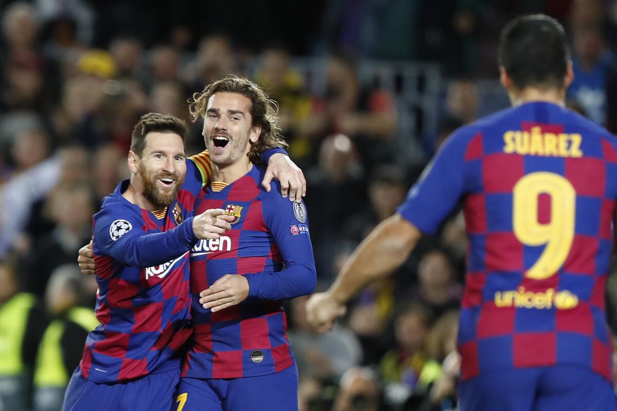 Lionel Messi (izquierda) festeja tras anotar el segundo gol del Barcelona junto a Antoine Griezmann (centro) y Luis Suárez en el partido contra Borussia Dortmund en la Liga de Campeones, el miércoles 27 de noviembre de 2019. (AP Foto/Joan Monfort)
