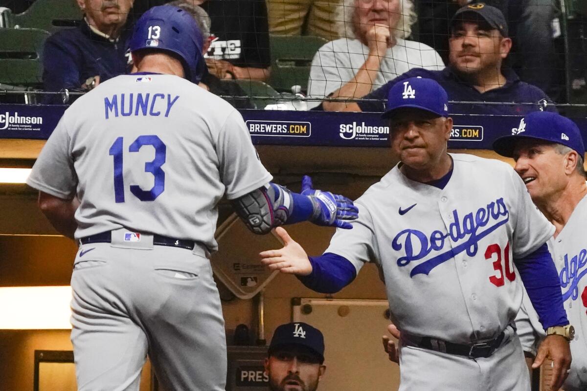 Max Muncy is congratulated by Dodgers manager Dave Roberts after hitting a home run against the Milwaukee Brewers.