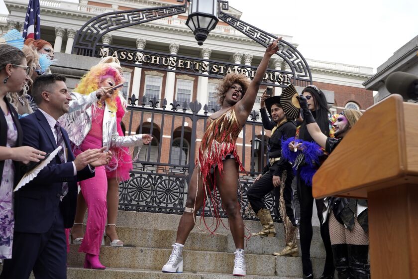 Drag performer Neon Calypso, center, sings and dances to Tina Turner's version of the song "Proud Mary," during a Pride Month Celebration, Wednesday, June 7, 2023, in front of the Statehouse, in Boston. The event included a performance of about a dozen drag performers at a time when some states have tried to target drag performances. (AP Photo/Steven Senne)