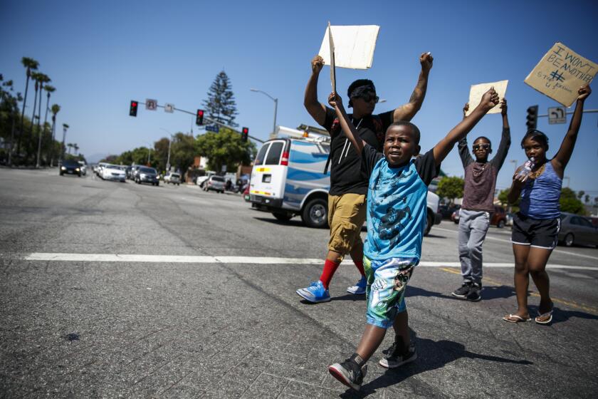 Mac Bevans, left, and Karone Tolliver, 5, march with protesters in Los Angeles on Thursday after the recent deaths of Alton Sterling and Philando Castile at the hands of the police in other states.